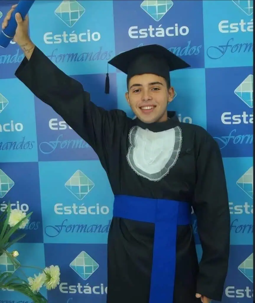 Aprovado em faculdade de direito com orgulho e felicidade em cerimônia de graduação. Jovem estudante celebra conquista acadêmica usando toga e capelo em evento formal na instituição Estácio.