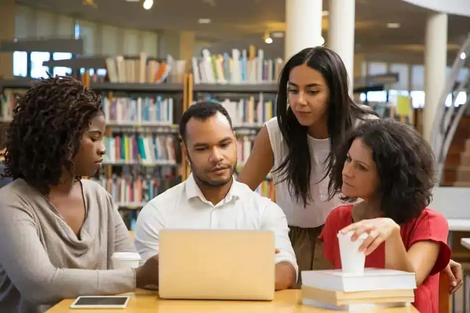 Estudantes discutindo legislação e direitos no ambiente de biblioteca para se manterem informados sobre temas jurídicos atuais.