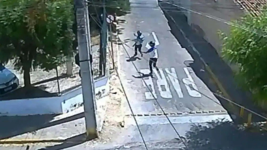 Adaptação de imagens para SEO: um homem ameaçando outro com uma arma em uma rua urbana. Cena de conflito, violência urbana, segurança pública e direito.