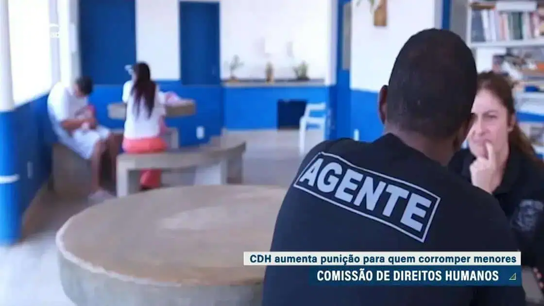 Direito Hoje Notícias, agente da polícia conversando com mulher em ambiente de atendimento social, promovendo proteção de menores e reforçando punições contra crimes cometidos contra crianças.