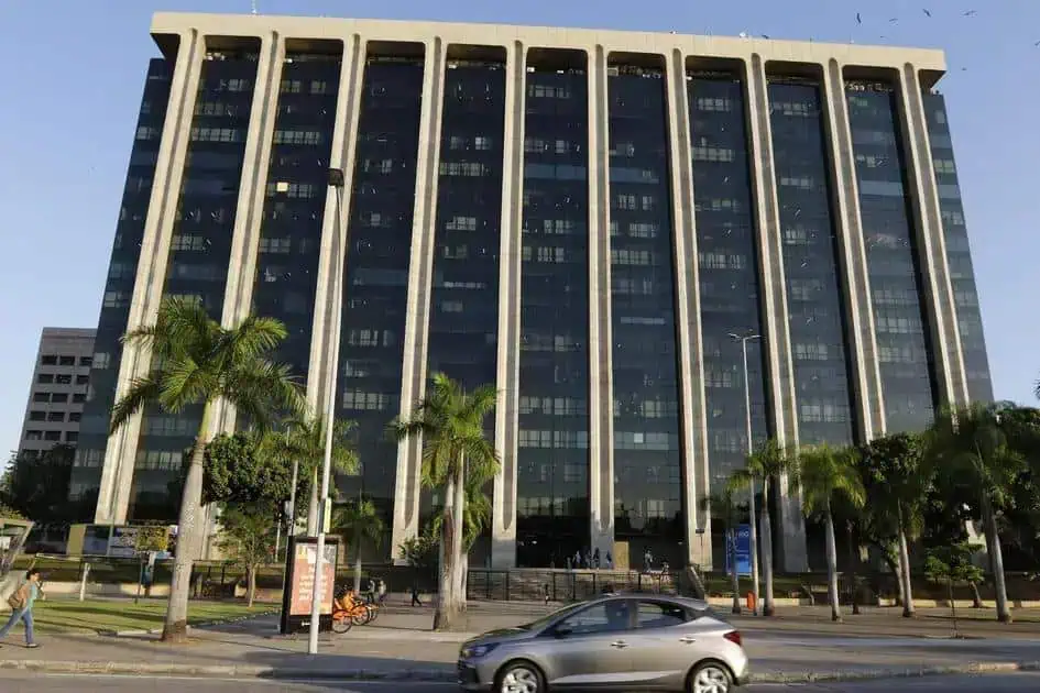 Direito Hoje Notícias, prédio corporativo moderno com fachada de vidro, ao lado de árvores e trânsito movimentado, destaque para notícias jurídicas, direito e legislação em ambiente urbano de São Paulo.