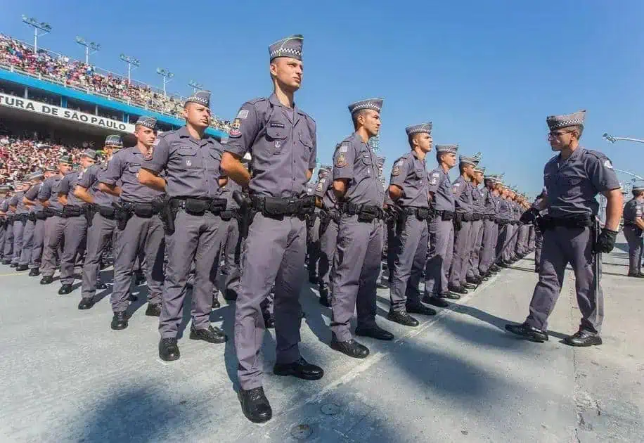 Segurança pública e polícia militar em formação durante evento esportivo com público no estádio de São Paulo.
