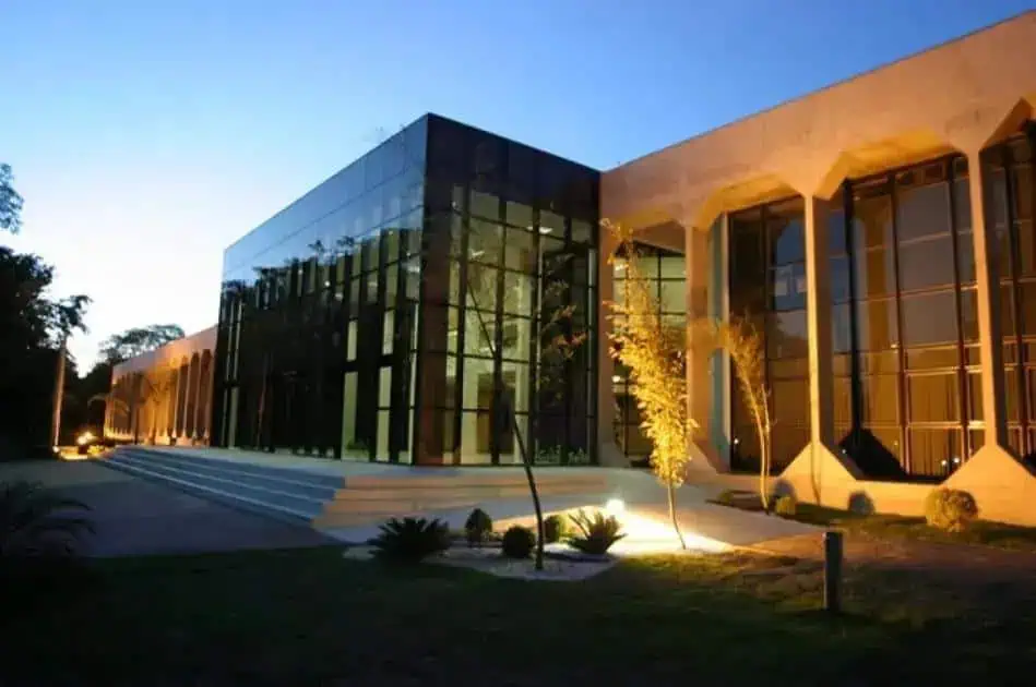 Prédio moderno de arquitetura contemporânea com fachada de vidro e iluminação noturna, representando inovação no setor jurídico e notícias em direito no Brasil.