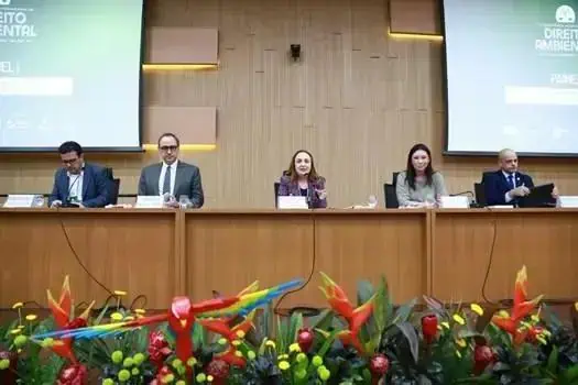 Profissionais participando de painel em evento jurídico com destaque para debates sobre direito e inovação, com banners do Direito Hoje Notícias ao fundo.