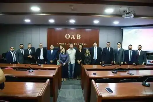 Profissionais do Conselho Federal da OAB posando para foto em evento jurídico no plenário.