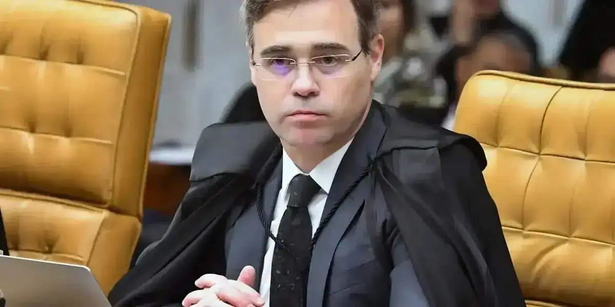 Supremo do Tribunal de Justiça, juiz em sessão, julgando processo, com expressão séria, usando toga preta e gravata, em ambiente judicial formal, assinado na bancada de julgamento.