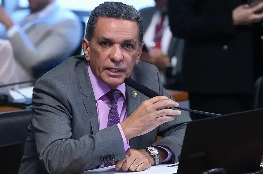 Advogado falando em audiência com microfone em ambiente de tribunal, foco na importância de direito e justiça.