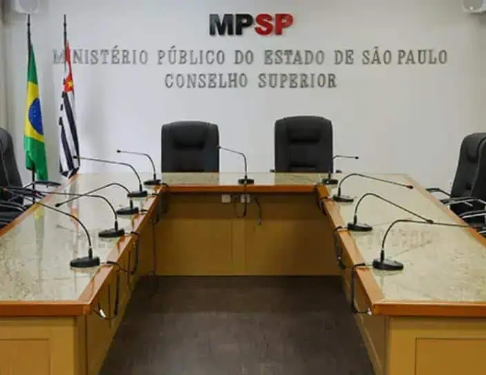 MP SP Ministério Público São Paulo, Conselho Superior, sala de reunião oficial com bandeiras do Brasil e de São Paulo ao fundo, imagens de escritórios jurídicos.