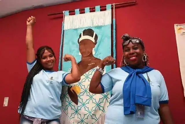 Mulheres profissionais do direito posicionando-se com força e coragem em frente a uma obra de arte que celebra o empoderamento feminino.
