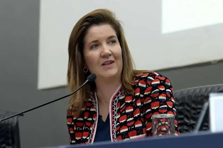 Advogada de frente, falando em painel de conferência, direito hoje notícias, mulher em evento jurídico, assuntos de direito e legislação, representação de profissionais do direito, discurso em evento jurídico, advogado em palestra, direitos humanos, temas jurídicos atuais, justiça e legislação brasileira.