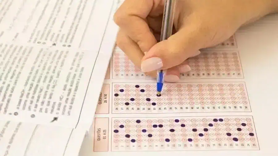Prova de concurso sendo preenchida com resposta de bolinhas e caneta azul para questões de direito, foco em preparação legal e estudo para concursos públicos do Brasil.
