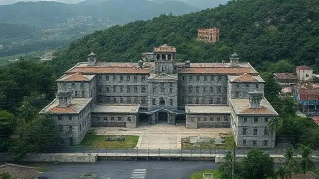 Castelo histórico no centro de uma cidade com montanhas ao fundo, destacando-se por sua arquitetura antiga e importância cultural no contexto do direito e história.
