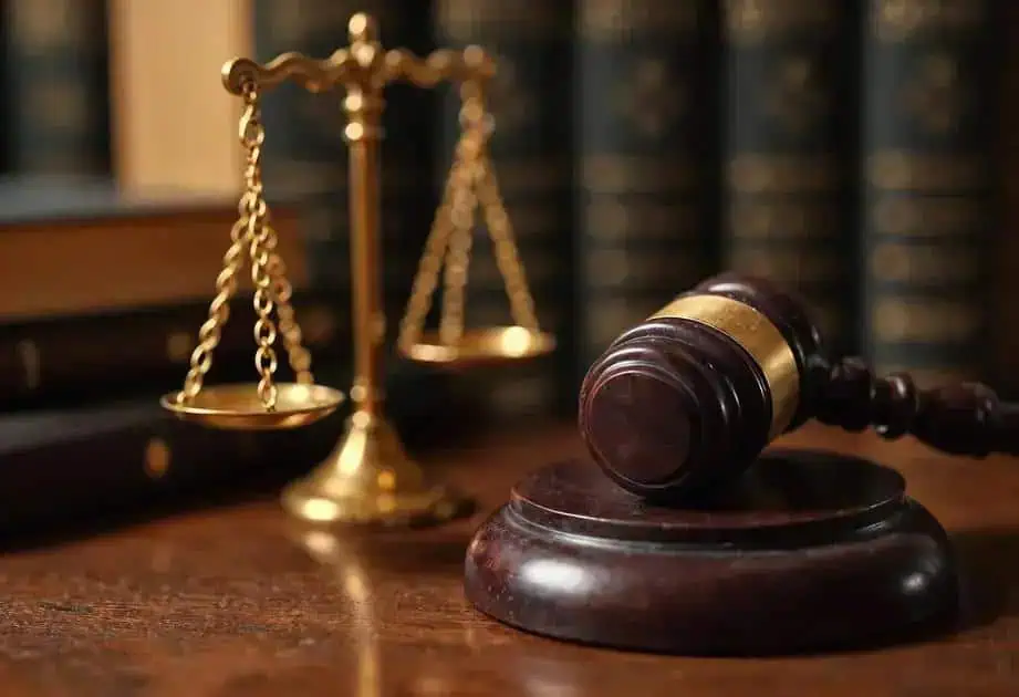 Balança da justiça e martelo de juiz em ambiente jurídico, símbolo de direito e tribunais.