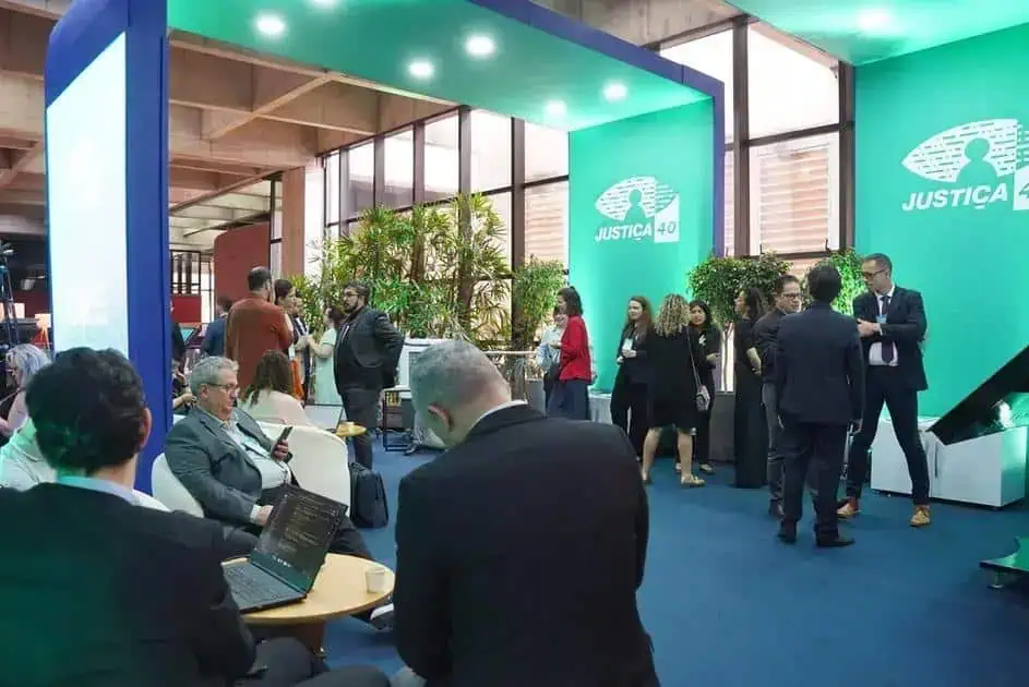 Direito Hoje Notícias, evento com público discutindo temas de justiça e direito em ambiente moderno e profissional, com destaque para a marca Justiça 40.
