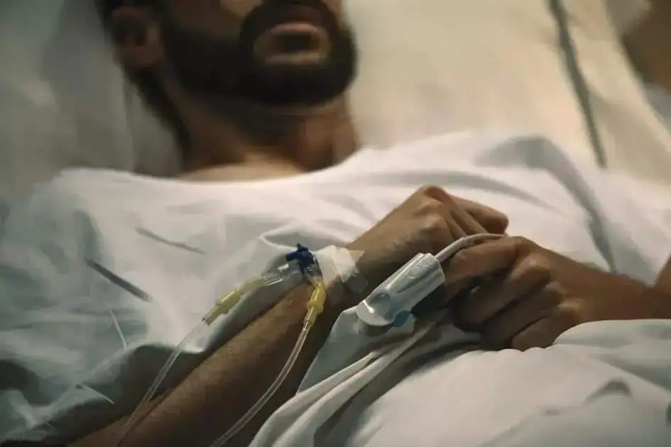 Paciente em estado grave recebendo cuidados médicos em hospital.