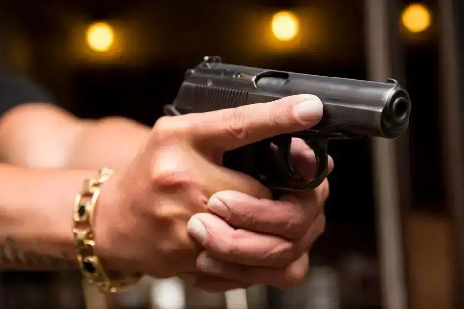 Segurança e Crime: policial com arma de fogo apontada, foco em controle de armas e combate à violência no Brasil.