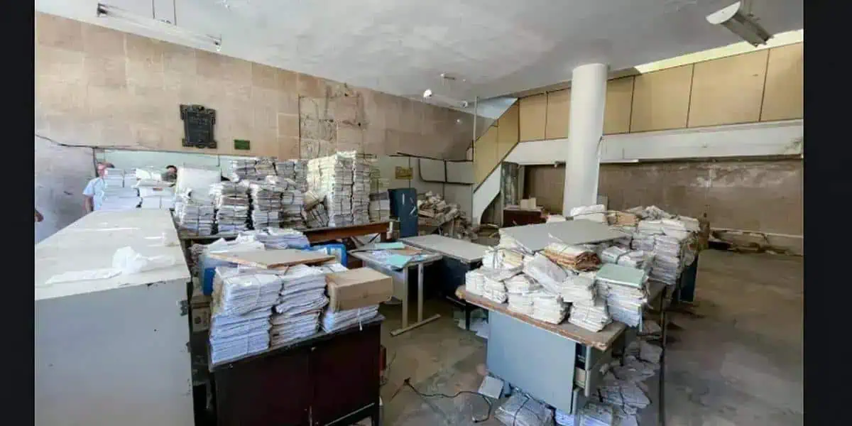 Pilhas de processos jurídicos amontoados em escritório de advocacia, simbolizando excesso de documentação e necessidade de organização em escritórios de direito.