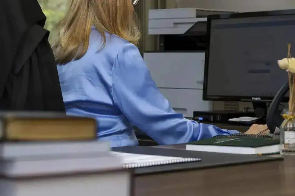 Segurança no ambiente de trabalho, com foco em legislação e direitos trabalhistas, representada por uma profissional utilizando computador em escritório.
