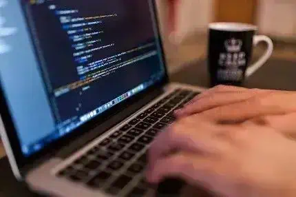 Codificação de código fonte em laptop com foco em direito e notícias jurídicas, ambiente de trabalho digital.