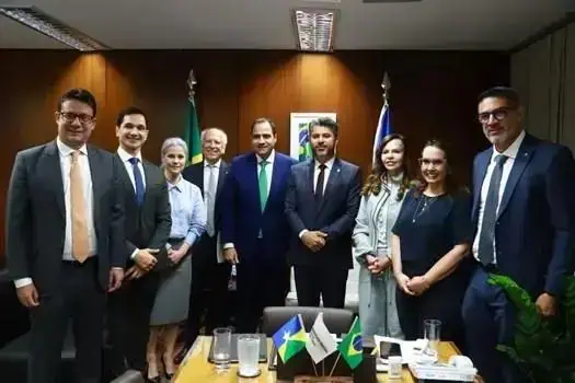 Reunião de profissionais do direito e autoridades com bandeiras do Brasil e do Estado, discutindo temas jurídicos relevantes e fortalecimento das instituições no contexto legal.