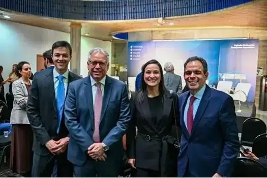 Homens e mulher em evento jurídico realizado no auditório do Direito Hoje Notícias, painel de discussão sobre direito, justiça e atualidades no setor jurídico brasileiro.