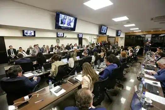 Salão de reunião jurídica com profissionais e advogados participando de um evento ou assembleia.