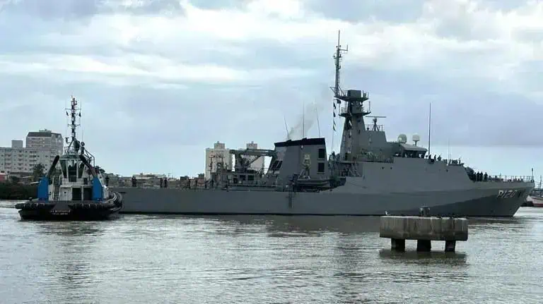Navio de guerra militar navegando próximo à cidade, com céu nublado ao fundo, símbolo de defesa e segurança marítima, destaque em notícias de direito e força naval.