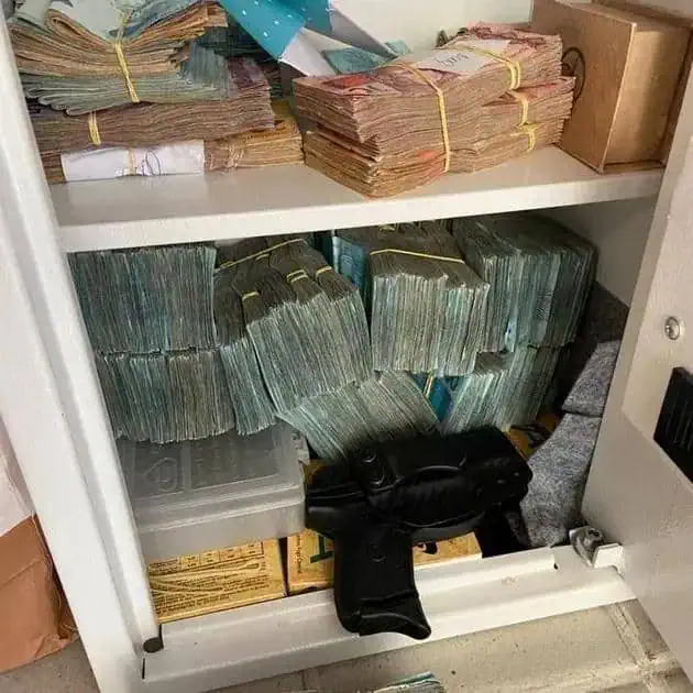 Pilhas de dinheiro guardadas em cofre, destacando segurança financeira, dinheiro em espécie, economia, e proteção de recursos.