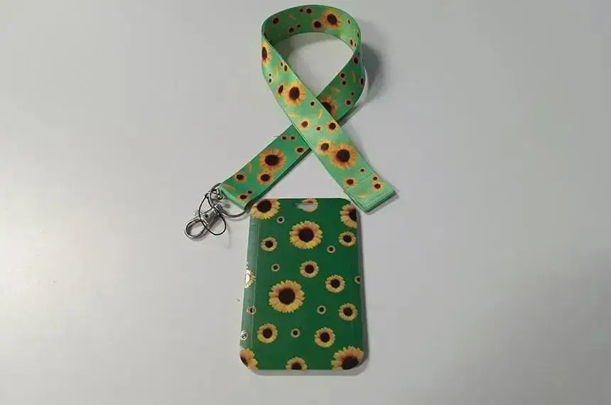Luva de celular com estampa de girassóis e fita de identificação, ideal para proteção e organização em ambientes jurídicos e notícias sobre direito.