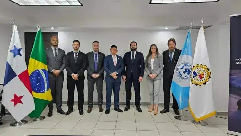 Brasileiros e representantes internacionais em evento jurídico, com bandeiras do Brasil, Panamá, Guatemala e ONU, promovendo cooperação e diálogo na área de direito e justiça.