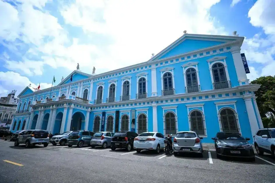 Prédio histórico azul do Poder Judiciário de Curitiba com carros na frente, símbolo de justiça e direito no Brasil.
