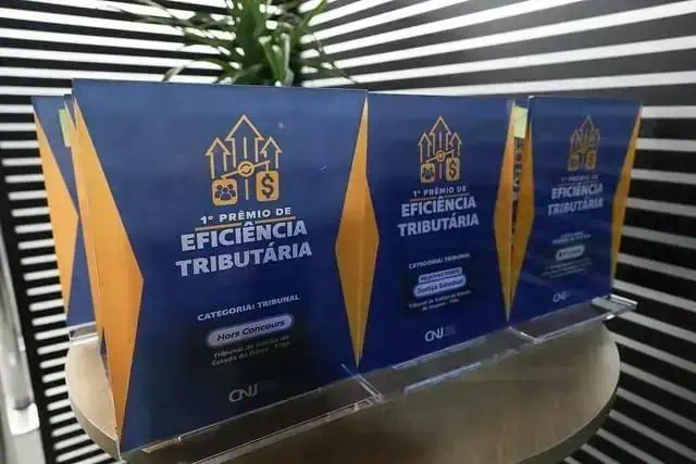 Prêmios de reconhecimento na área de eficiência tributária expostos em cerimônia de premiação, destacando sucesso no setor jurídico e fiscal.