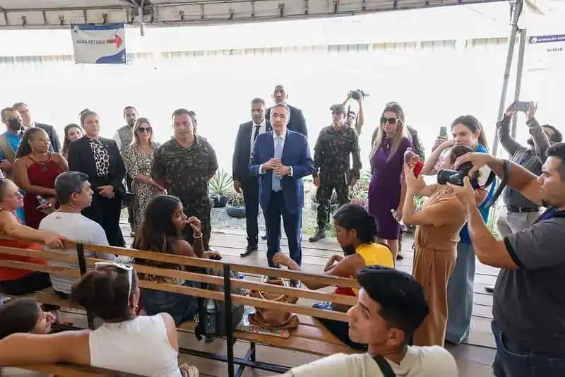 Ministro da Justiça conversa com visitantes em evento de direitos humanos, destacando políticas públicas e justiça social no Brasil.