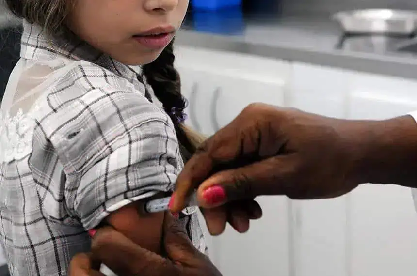 Vacina infantil sendo aplicada por profissional de saúde com foco em imunização e direitos das crianças na área de saúde.