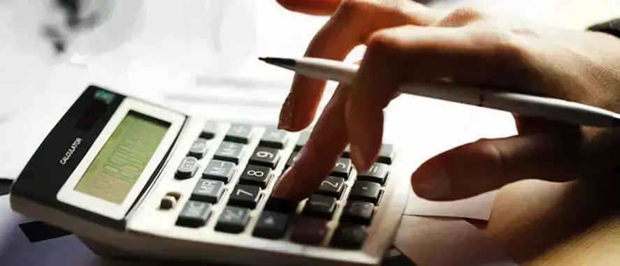 Cálculo financeiro com calculadora e caneta, símbolo de análise de dados econômicos e jurídicos, promovendo temas de direito financeiro, legislação, economia e notícias atuais do setor jurídico.