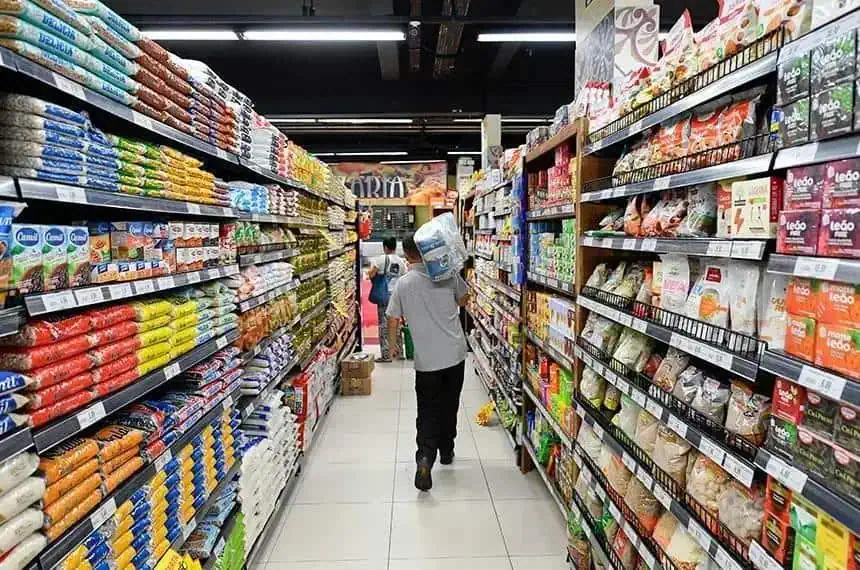 Pacientes com máscara de gás caminhando por corredor de supermercado com prateleiras repletas de alimentos e produtos embalados, no contexto de notícias de direito e saúde.