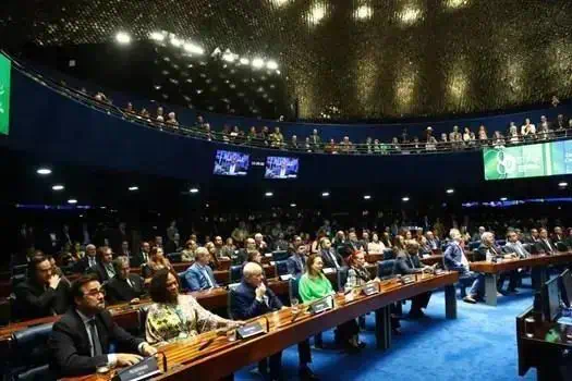 Salão de audiência do Congresso Nacional com parlamentares e autoridades em sessão legislativa, representando direito e políticas públicas no Brasil.