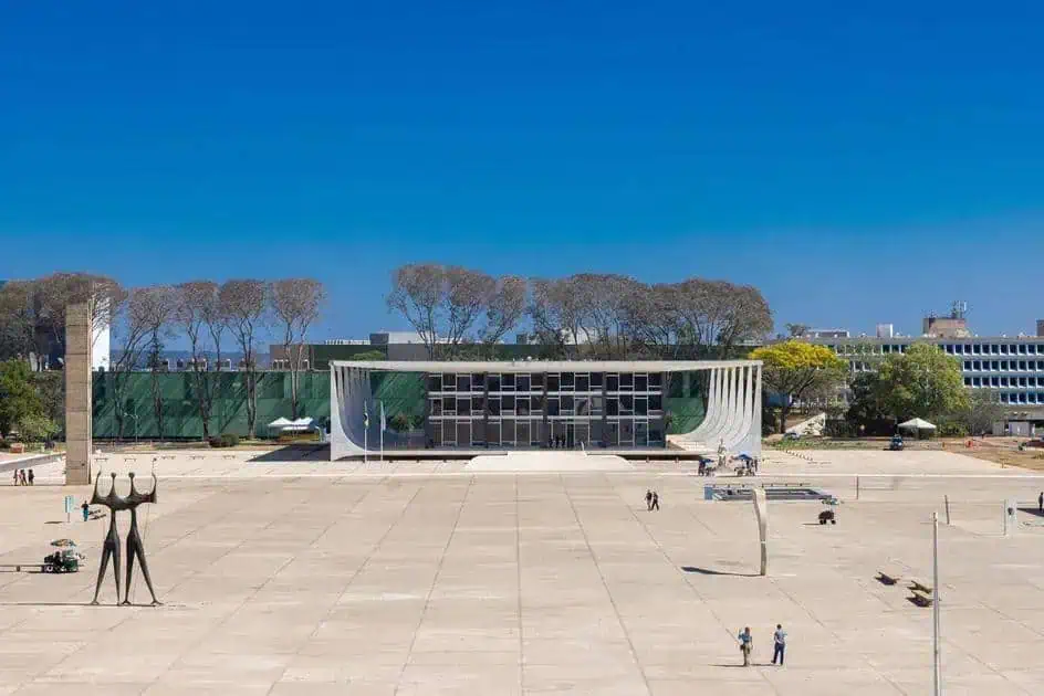 Praça Itamaraty em Brasília com o Palácio do Planalto ao fundo, céu azul claro e árvores ao redor, destacando arquitetura moderna, espaço aberto e importância política no Brasil.