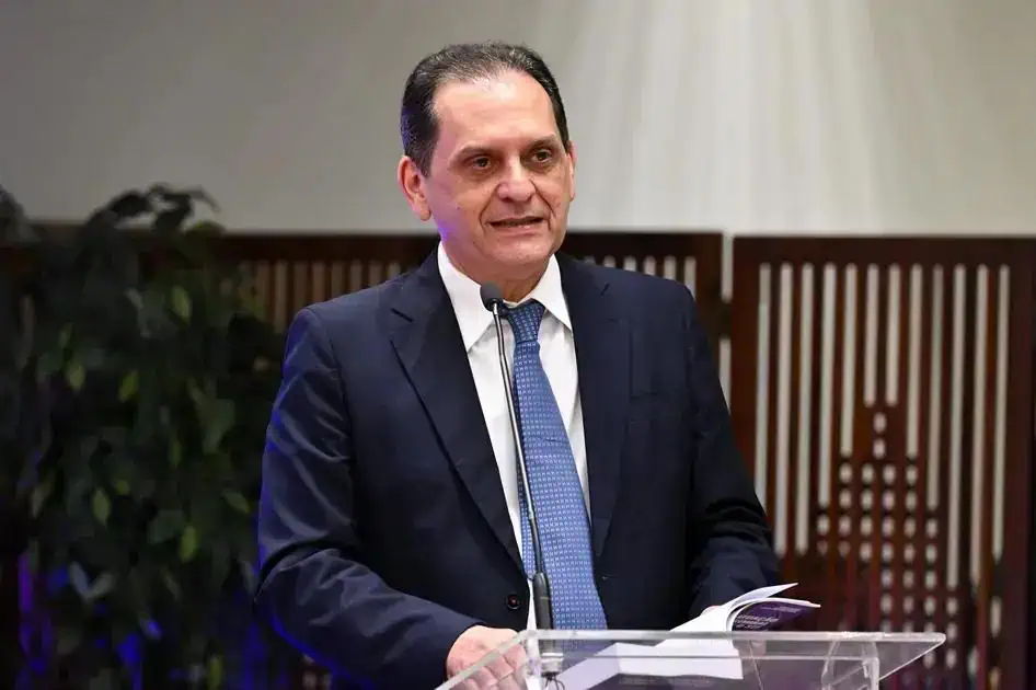 Direito Hoje Notícias, imagem de homem discursando em evento jurídico, com fundo de painéis de madeira, vestindo terno e gravata, representando notícias recentes e análises sobre direito e jurisprudência.