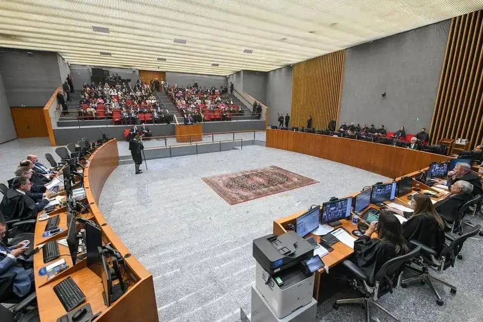 Decisão judicial em tribunal com juízes e advogados durante audiência, foco em direito e justiça, ambiente formal, direito hoje notícias, jurisprudência, direito constitucional, processo judicial.