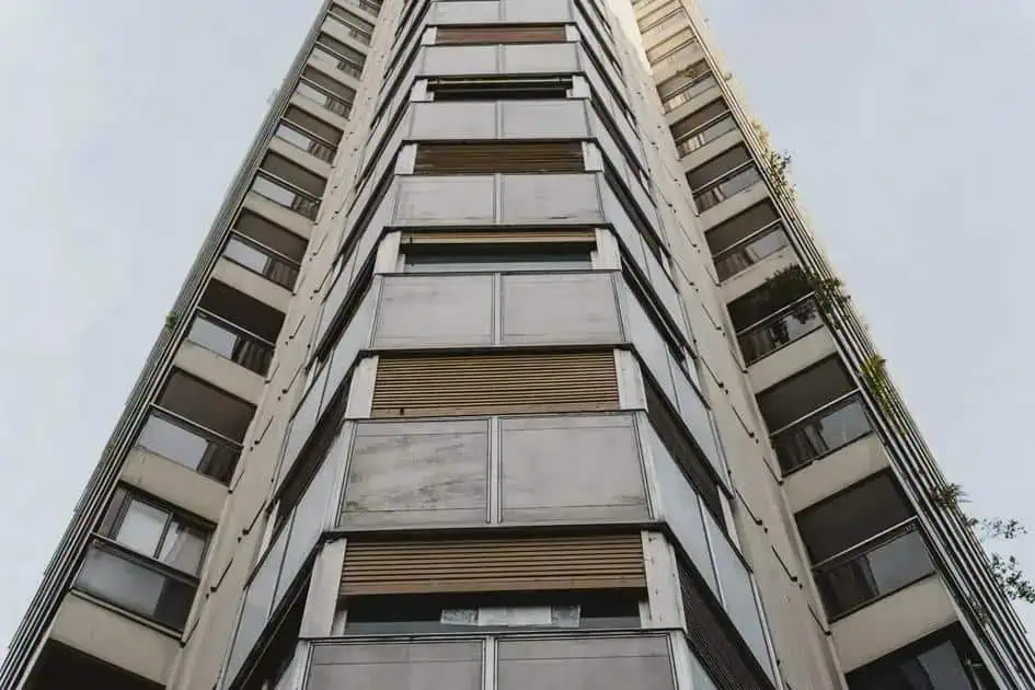 Apartamento de edifício residencial com janelas e varandas no centro urbano foco em imóveis e moradia Gestão jurídica de imóveis e condomínios, direito imobiliário e questões relacionadas a construção civil e propriedade vertical.