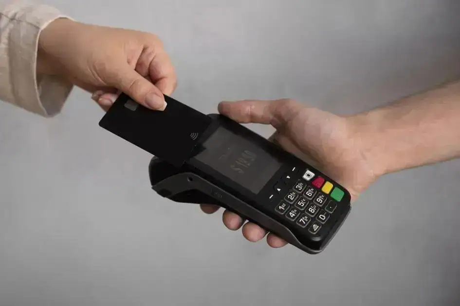 Pagamento com cartão de crédito sendo realizado em estabelecimento comercial, destacando acesso fácil e segurança nas transações financeiras.