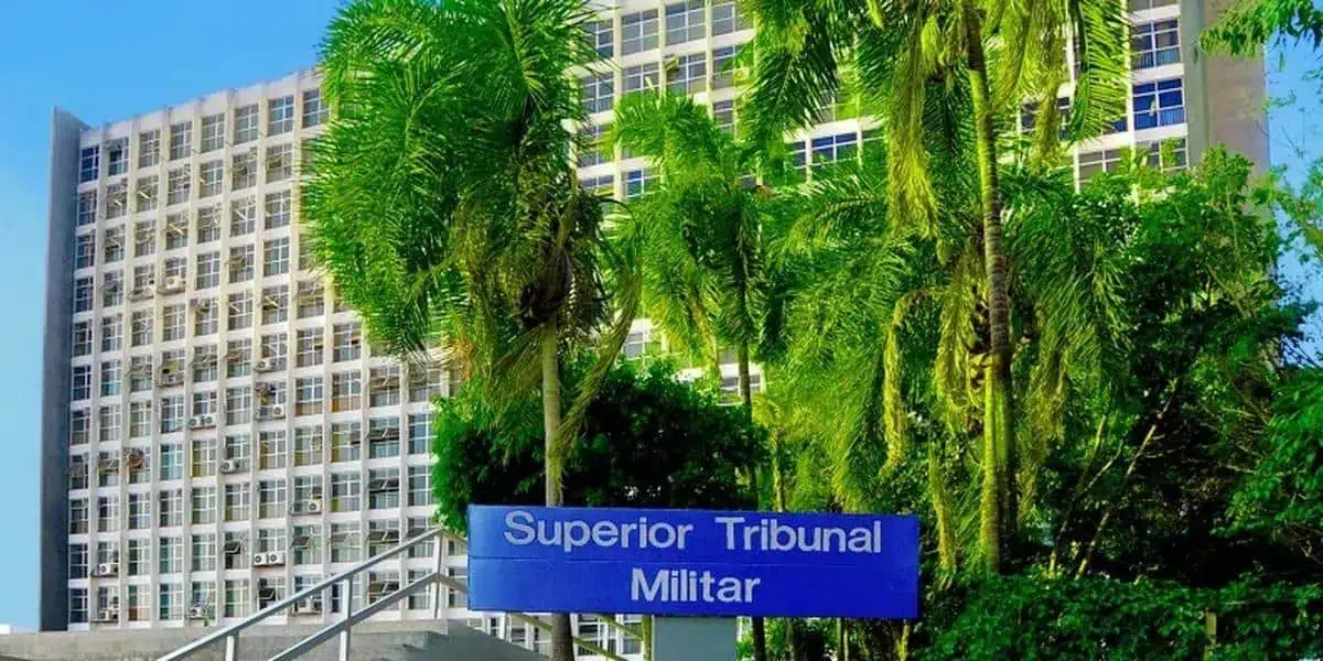 Superior Tribunal Militar, edifício com palmeiras na frente, clima ensolarado, foco nas questões jurídicas militares e notícias do direito militar.