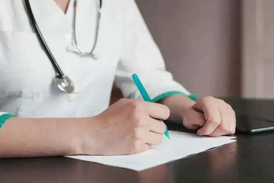 Exame médico sendo realizado por profissional de saúde usando jaleco branco e estetoscópio.