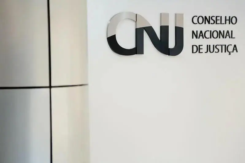 CNJ Conselho Nacional de Justiça logo na parede de uma sala de tribunal, representando o órgão que assegura a justiça e o estado de direito no Brasil.