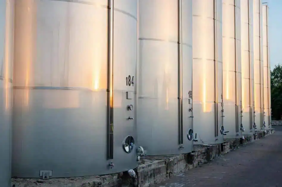 Tanques de armazenamento de líquidos metálicos em instalações industriais, representando segurança e regulamentação ambiental.