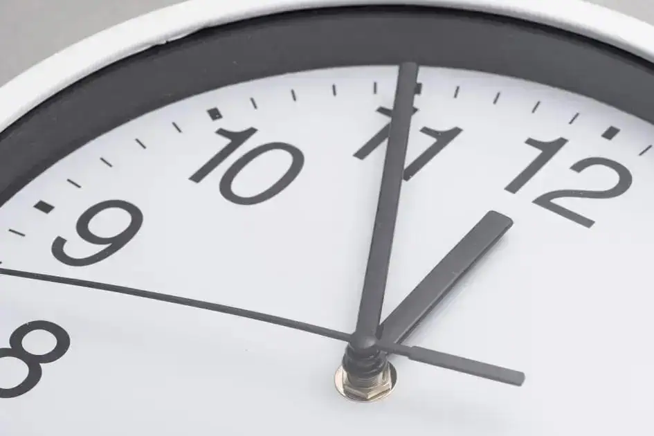 Relógio de parede marcando exatamente 12 horas, foco na medição do tempo, símbolo de pontualidade e gestão de prazos em temas jurídicos, leis e noticias atuais.