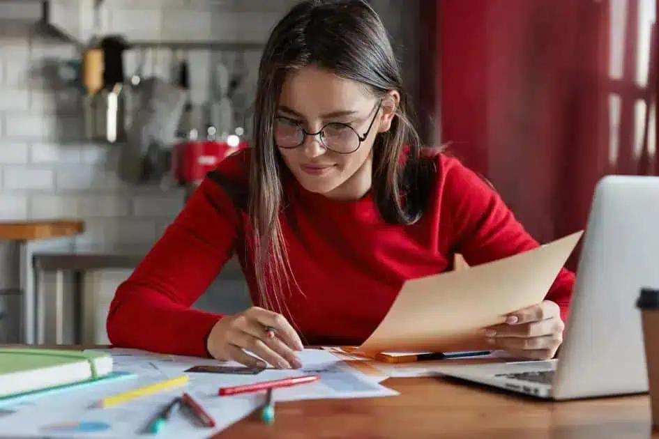Estudante estudando em casa com materiais de estudo e laptop, foco em direito, notícias jurídicas e atualizações legais, ambiente de estudo confortável e organizado.