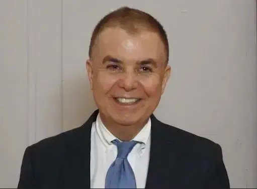 Homem de terno sorridente, apresentador ou advogado, em ambiente formal, representando notícias jurídicas e direitos, usado para ilustrar conteúdo do site Direito Hoje Notícias.