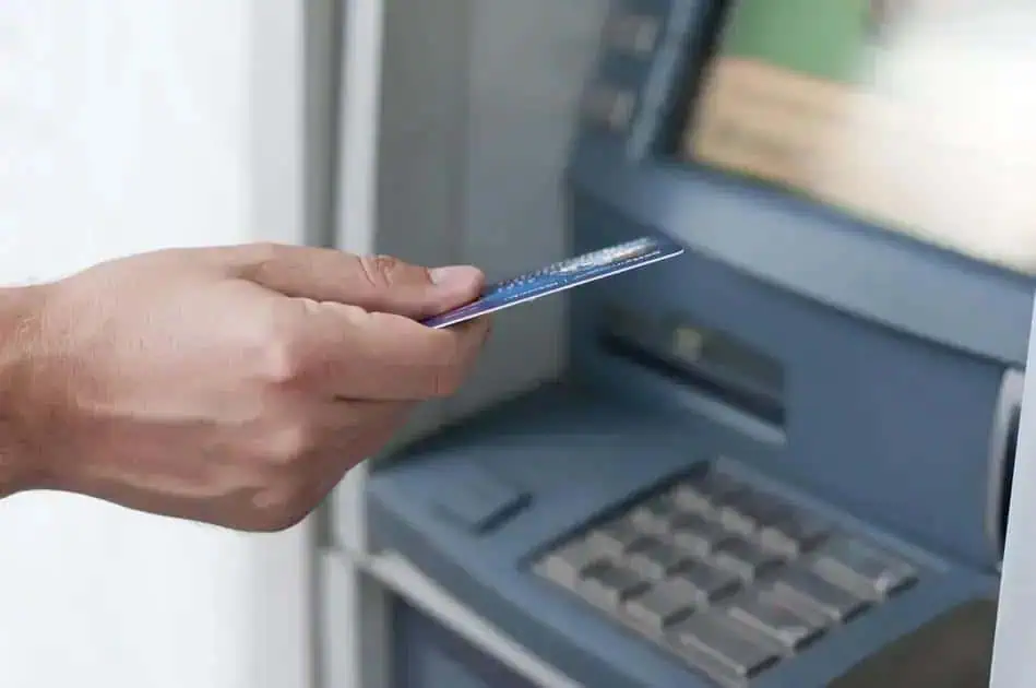 Cartão de débito sendo inserido em caixa eletrônico, transação bancária, tecnologia de pagamento digital, banco, operação financeira, segurança financeira, pagamento eletrônico, direito hoje notícias.